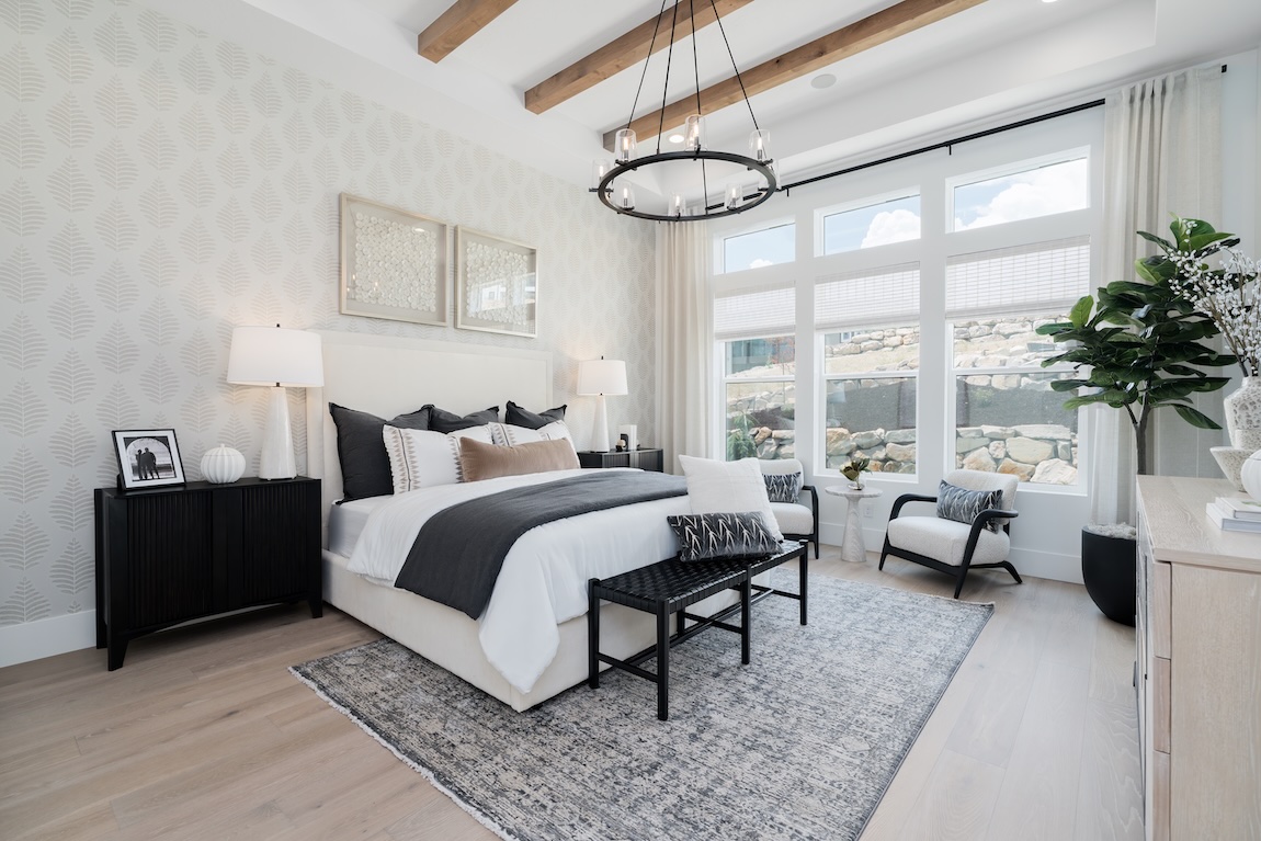 primary bedroom with chandelier and patterned wallpaper accent wall
