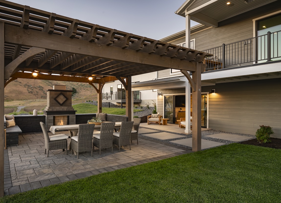 A subtly refined wooden pergola arching over the outdoor dining space.