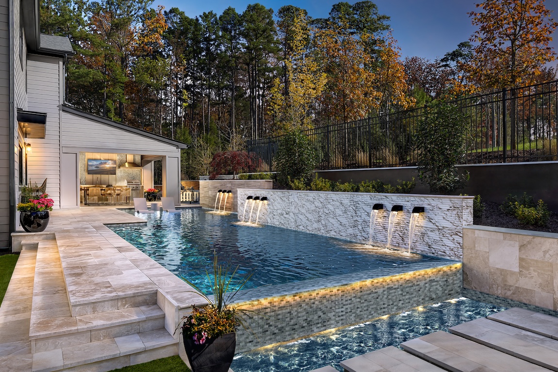Backyard pool with water features and lounge seating.