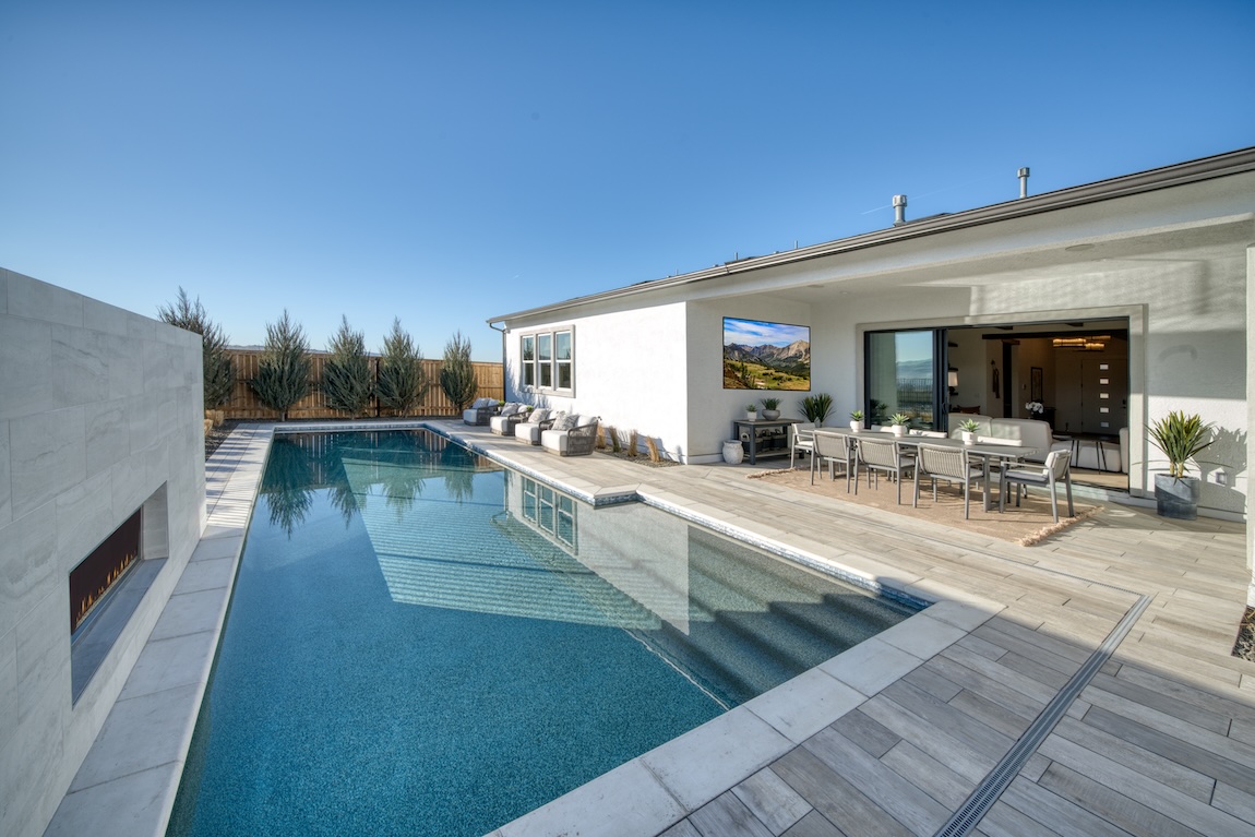 Functional, practical pool design with accompanying outdoor fireplace and seating area