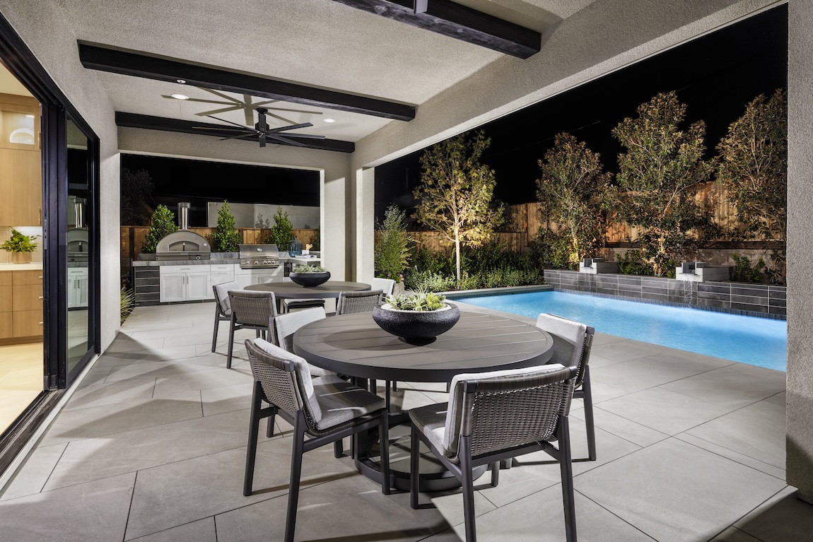 Covered patio with built-in grill and wood-burning pizza oven, featuring modern dining areas for stylish and functional outdoor barbecue gatherings.
