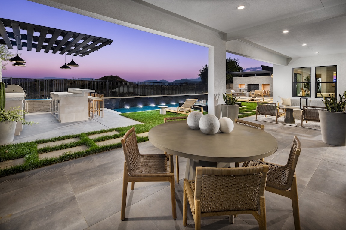 outdoor kitchen and dining space with pool views