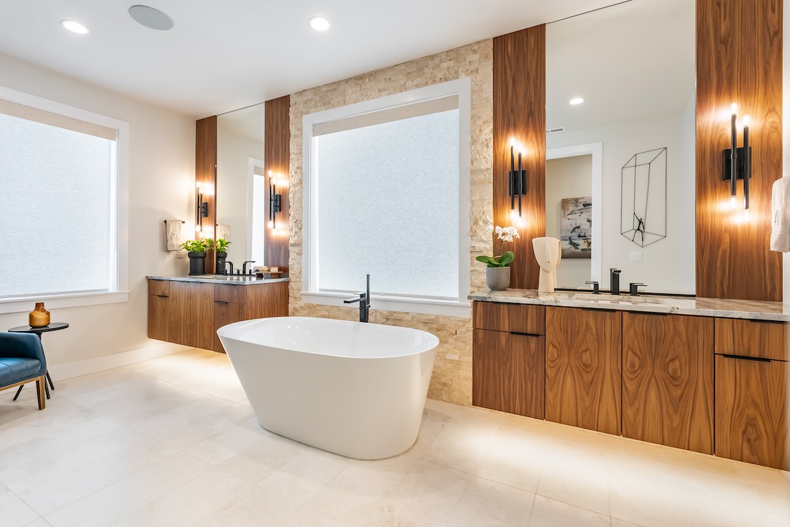 modern freestanding bathtub centered against a stone backdrop