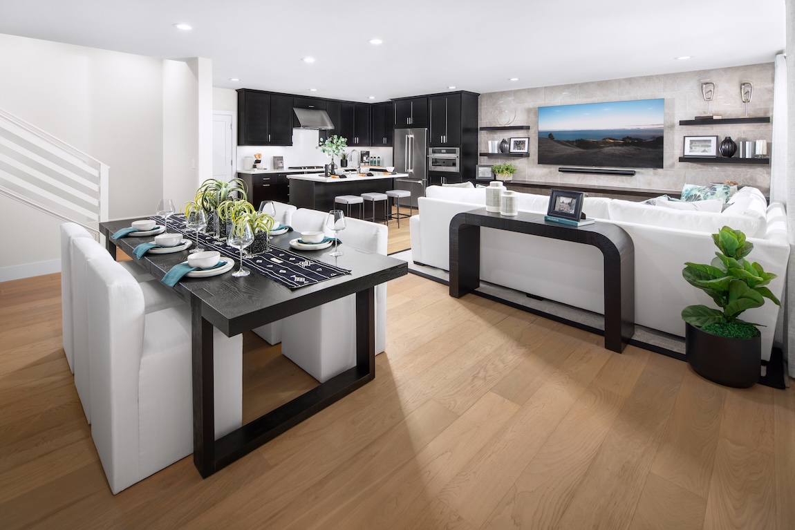 open-concept kitchen and living space with sleek black cabinetry and elegant wood flooring