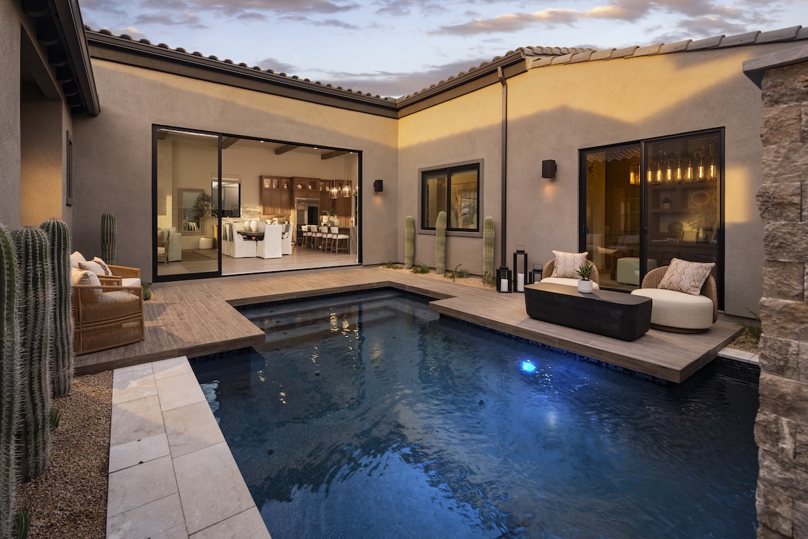 Private courtyard with a swimming pool, lounge seating, desert landscaping, and seamless indoor-outdoor living.