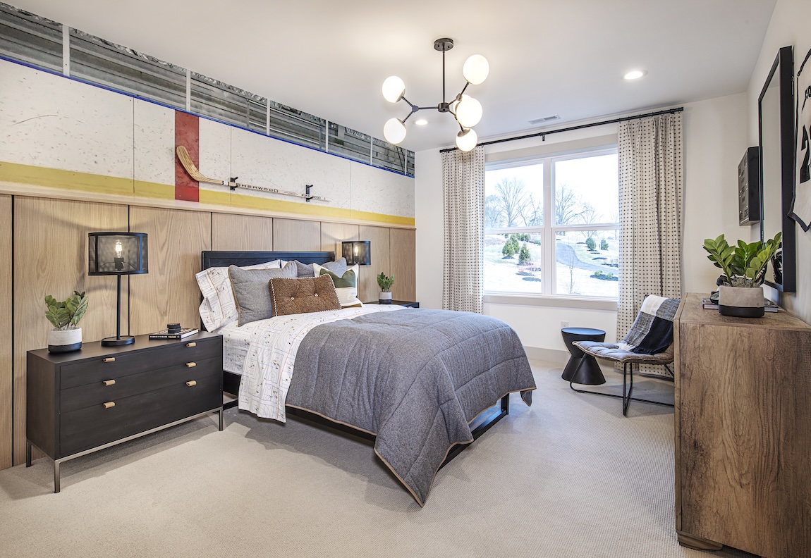 hockey-themed bedroom with wallpaper showcasing the boards of a rink