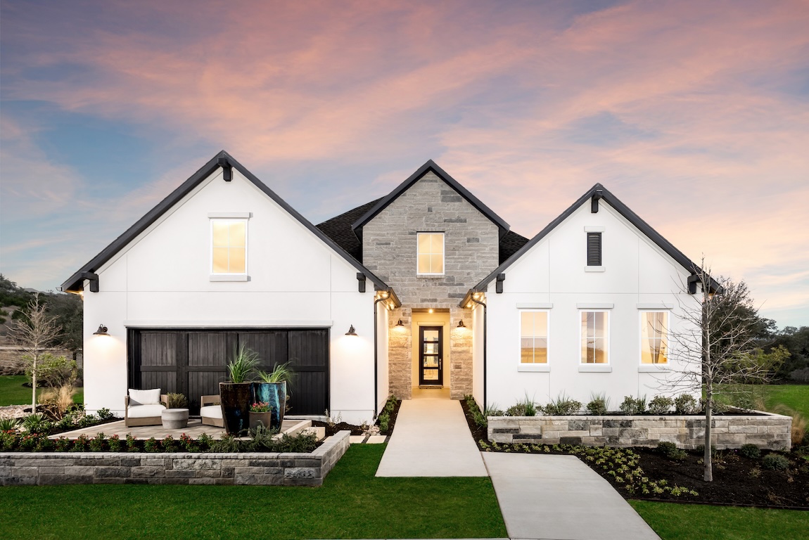 Texas hill country home design featuring front patio, stone materials, and white color scheme