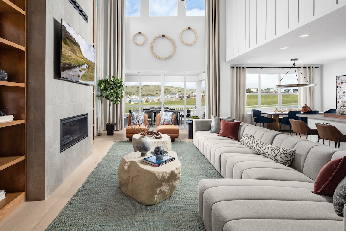 Luxury great room with soaring ceilings, sculptural furniture, and panoramic views through tall windows.