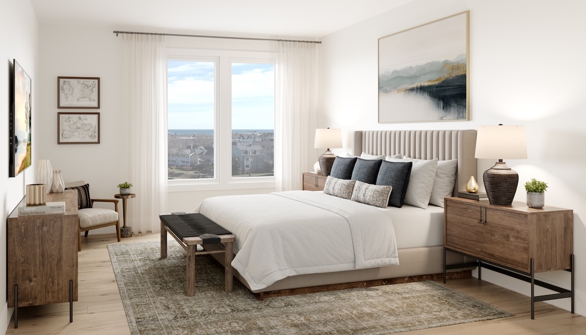Serene primary bedroom with upholstered bed, neutral bedding, wood nightstands, large windows with sheer curtains, and soft natural light.