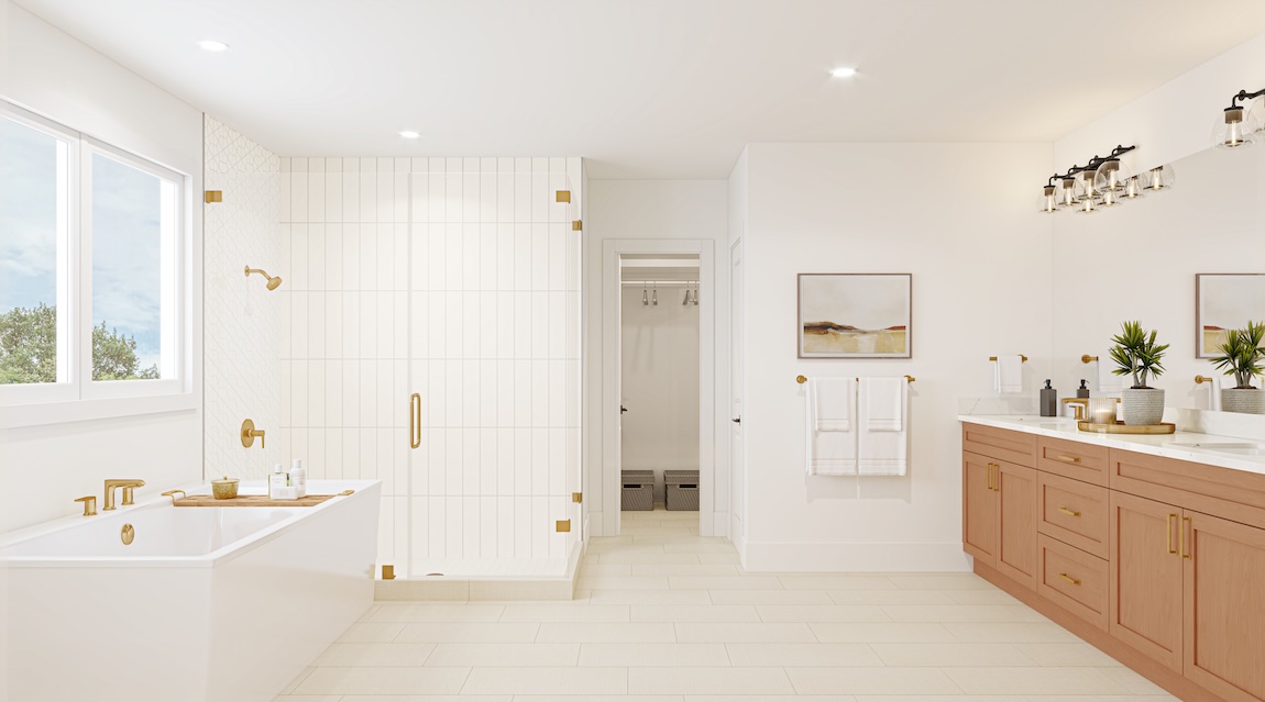 Spacious primary bathroom with freestanding soaking tub, glass-enclosed shower, double vanity with wood cabinetry, and warm brass fixtures.