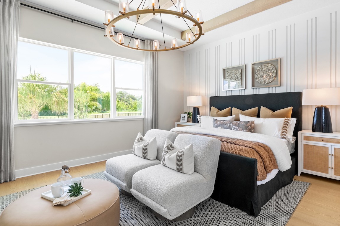 Primary bedroom with textured accent wall and plush seating.
