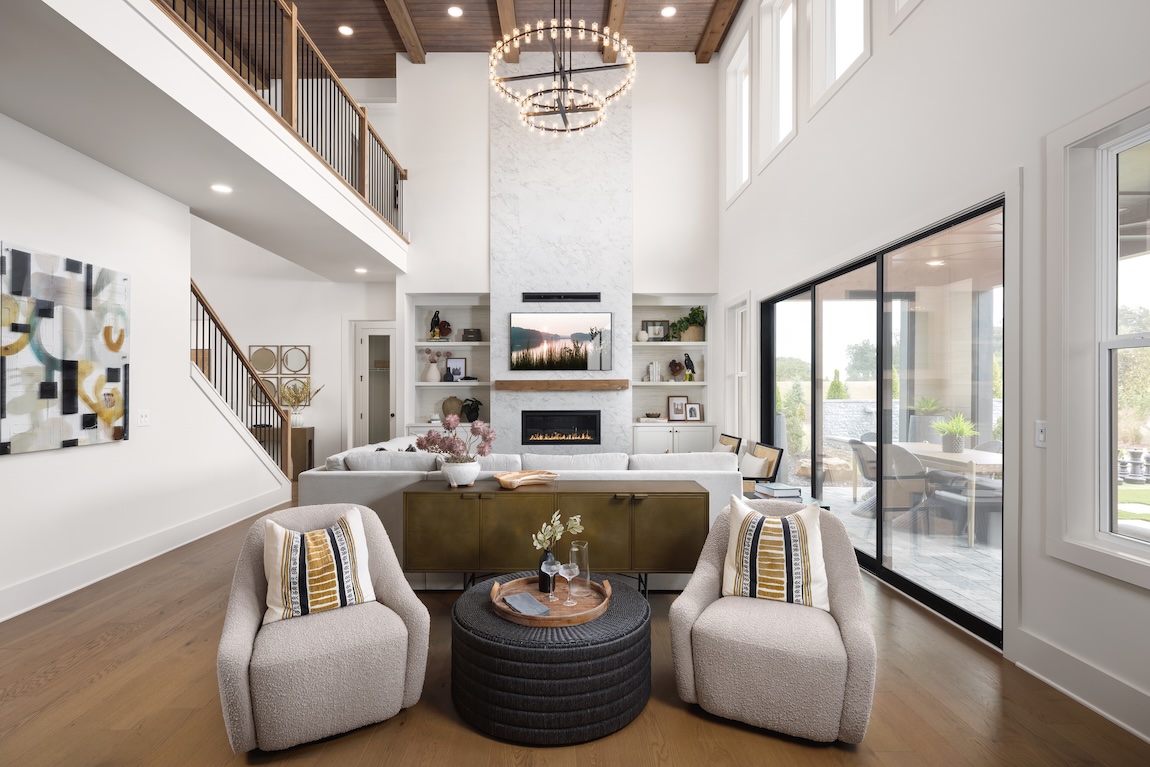 Modern farmhouse great room with wooden ceiling and statement chandlier.