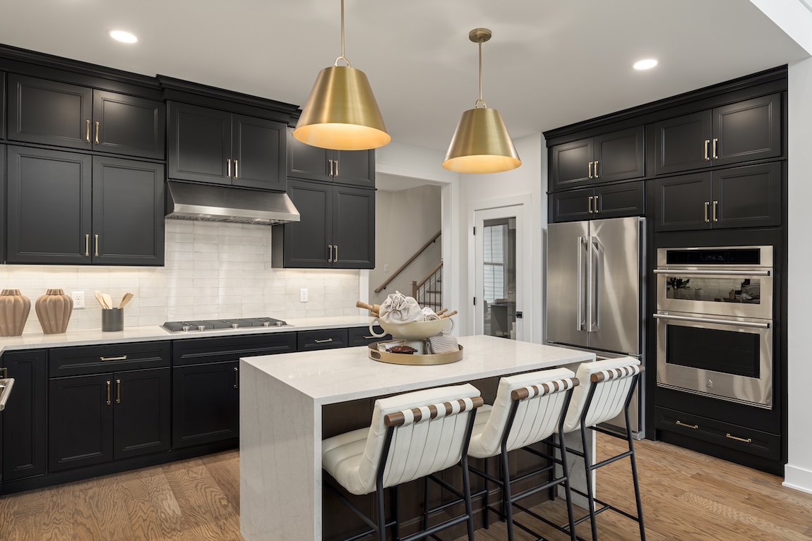 kitchen with black cabinetry and gold fixtures