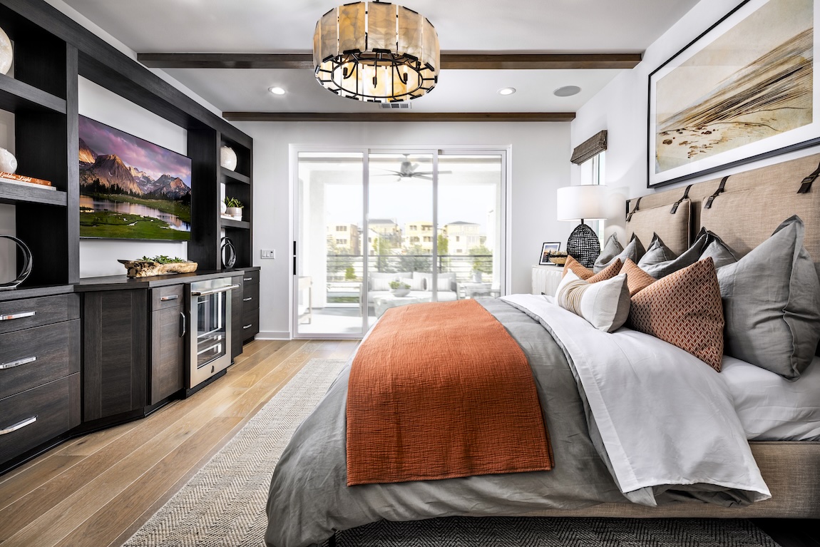 Primary bedroom with built-in shelving and glass doors to the outdoor patio space.