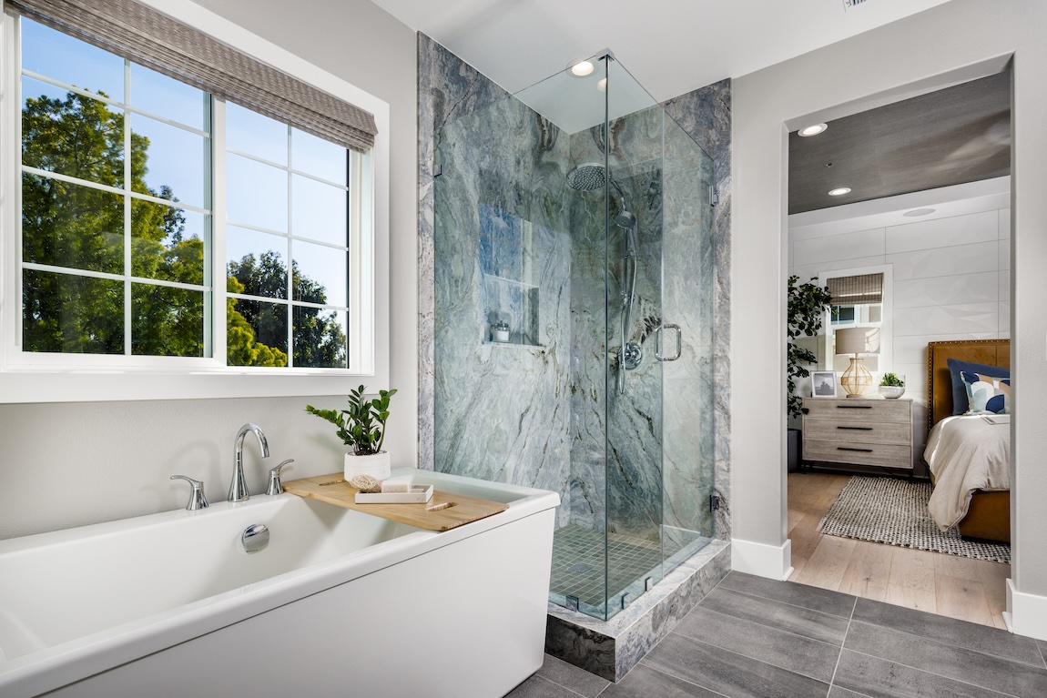 Primary bathroom with a shower with marble tile and a freestanding tub.