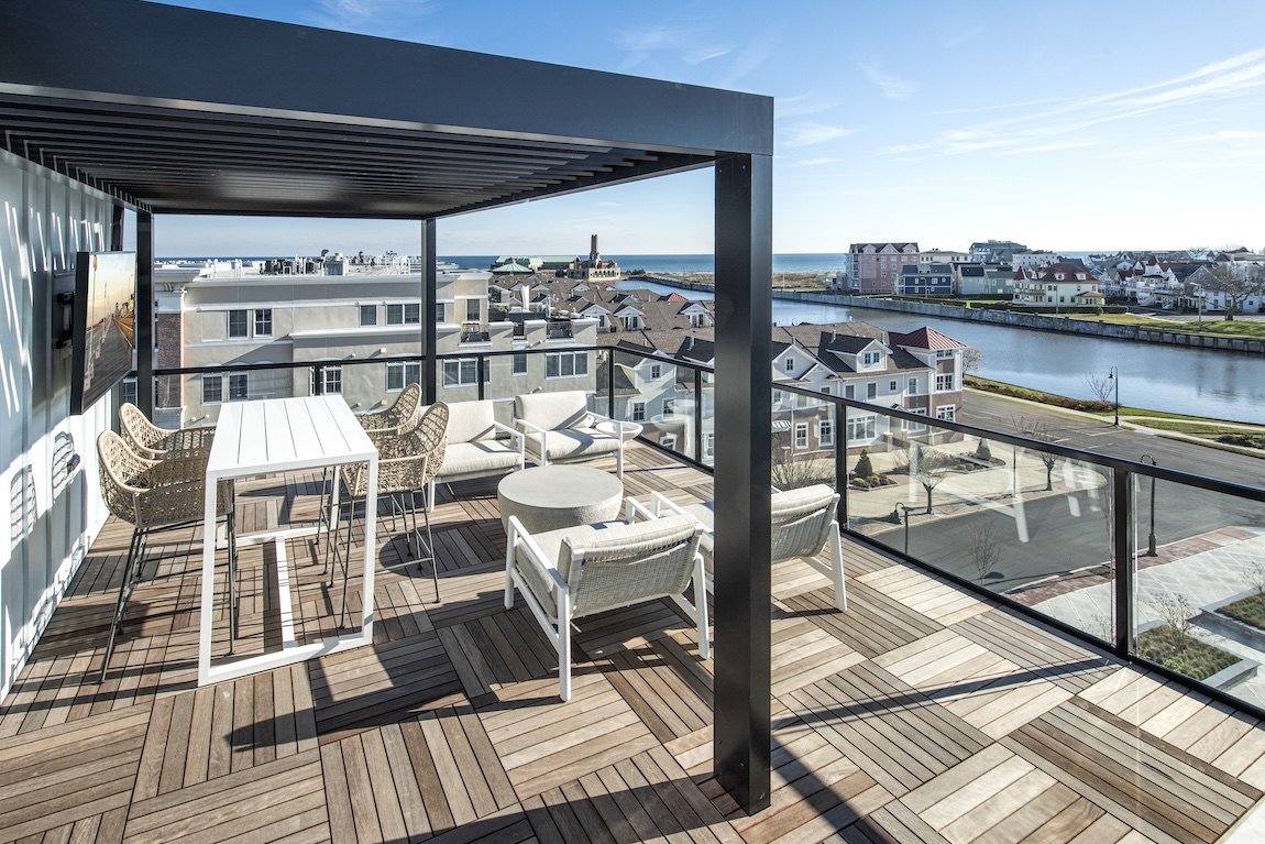 Upstairs porch with pergola and seating.