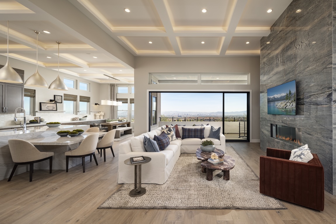 Modern luxury living room and kitchen with glass doors to the outdoor patio space.