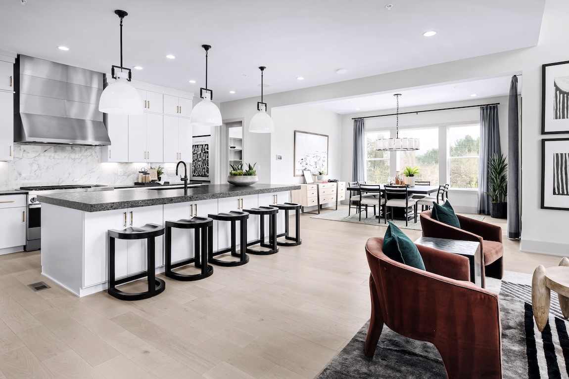 Modern kitchen with white cabinetry and open concept living to the dining and living area.
