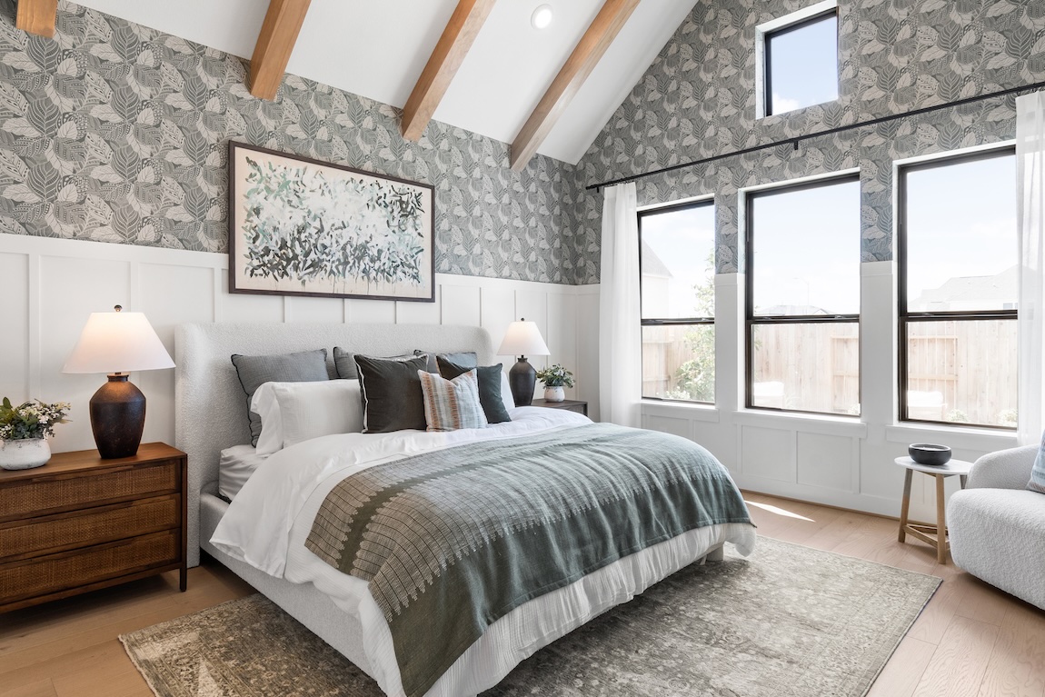 primary bedroom with a green color palette and large windows bringing in natural light