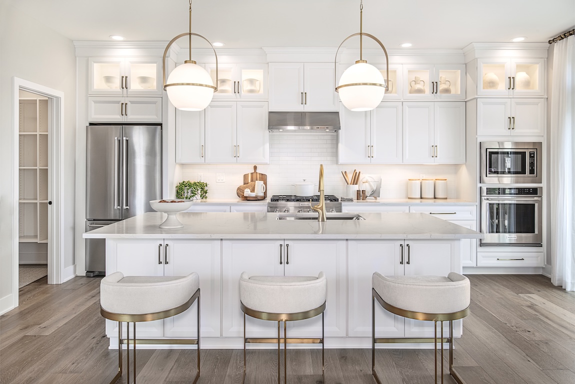 luxury kitchen with white cabinetry and globe pendant lights