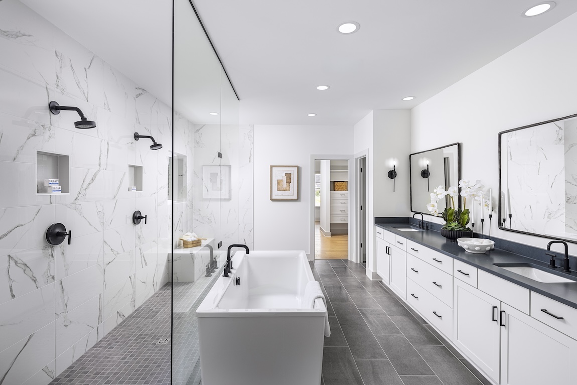 primary bathroom with marble tile and black fixtures