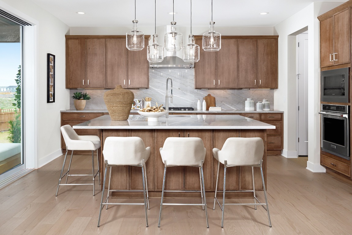 modern kitchen with wooden cabinetry and barstools.