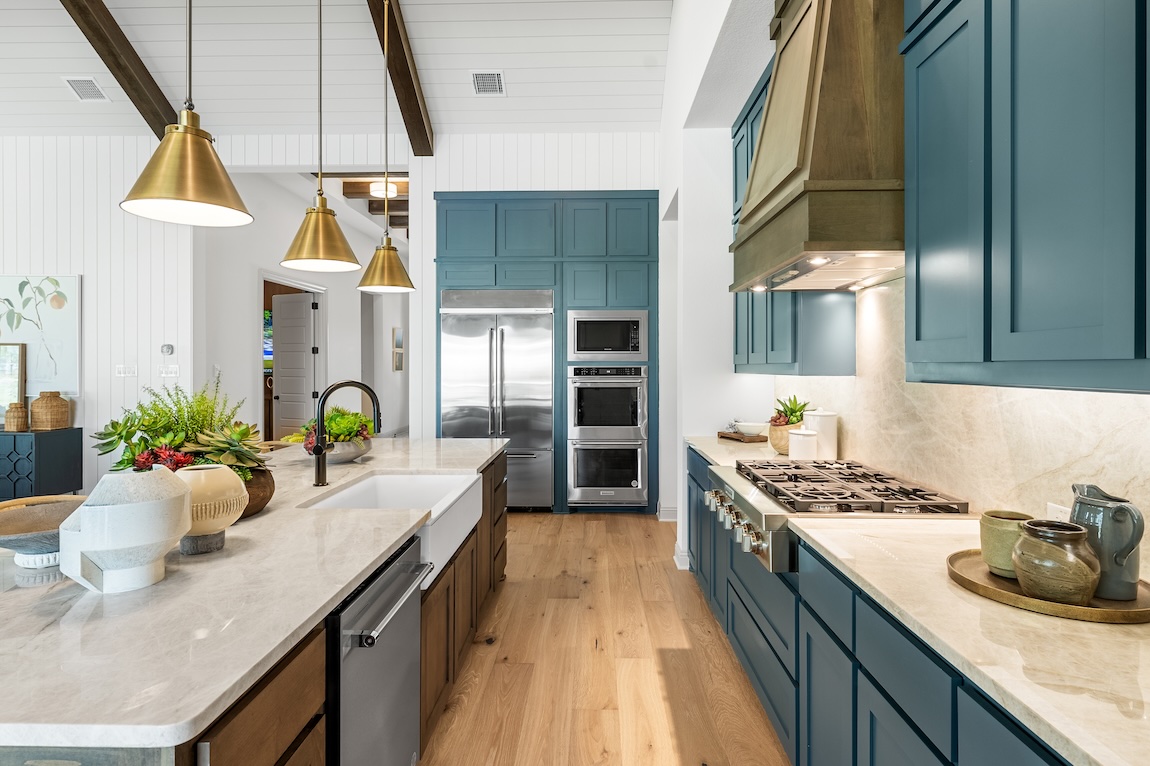 Two-tone kitchen with teal upper cabinets and warm wood accents showcasing colorful cabinet pairing ideas.