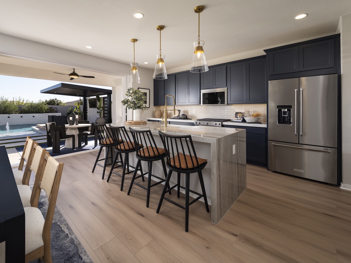 Dark navy kitchen cabinets paired with light countertops and wood flooring for a rich, contrasting cabinet look.
