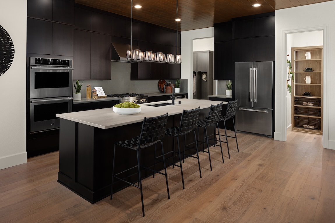 Modern kitchen with mixed cabinet finishes and waterfall island highlighting multi-tone cabinet design ideas.