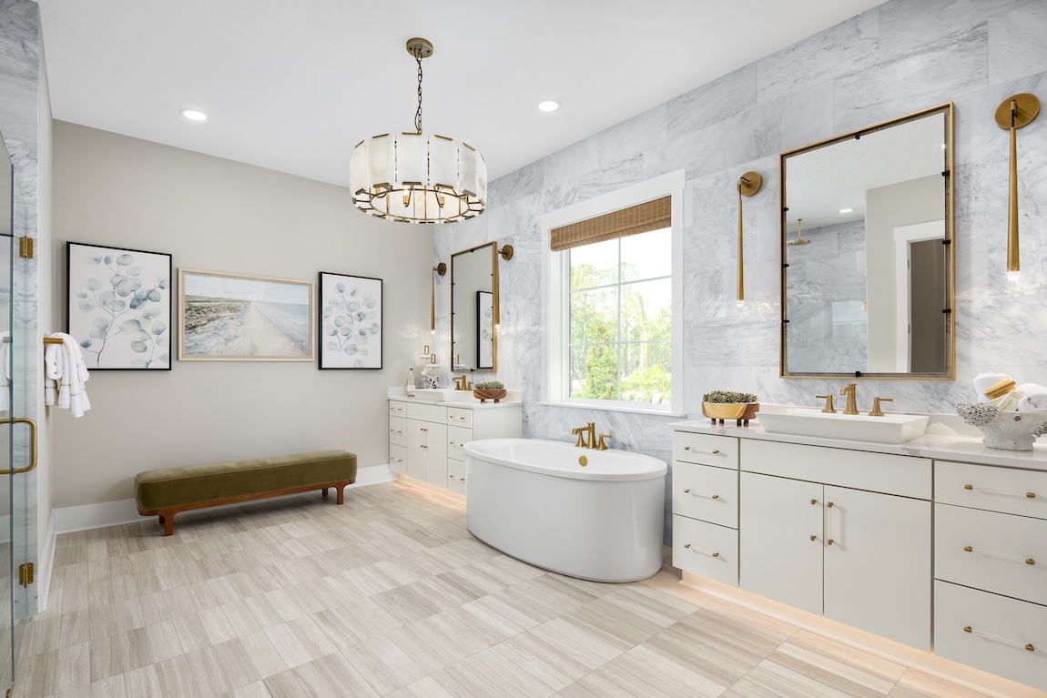 primary bathroom with marble tile wall and a statement chandelier
