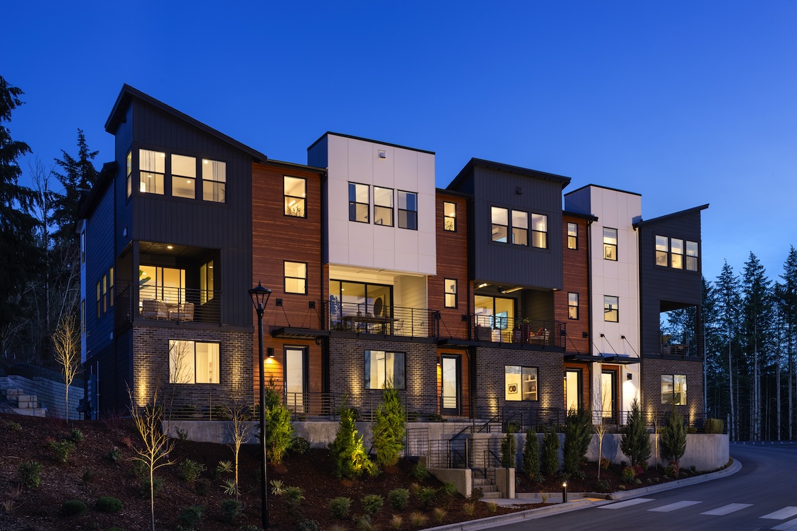 exterior of townhome with warm interior lighting