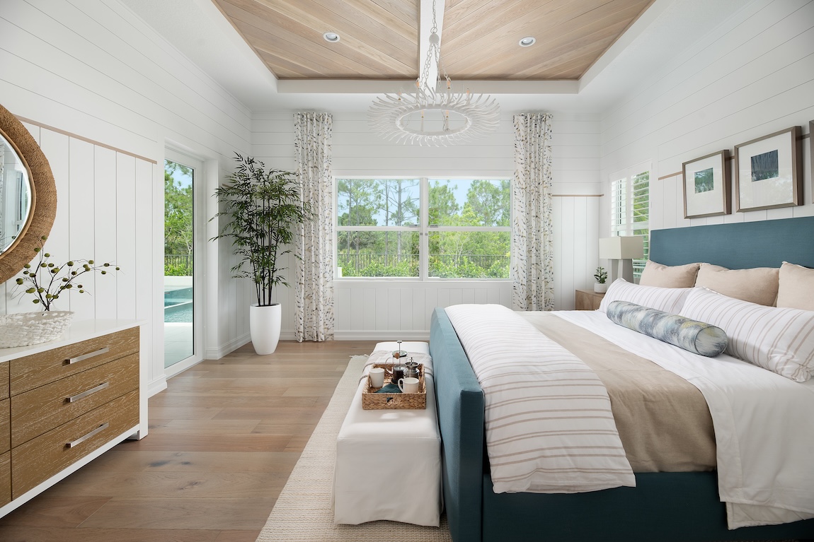 Primary bedroom with shiplap walls and natural light.