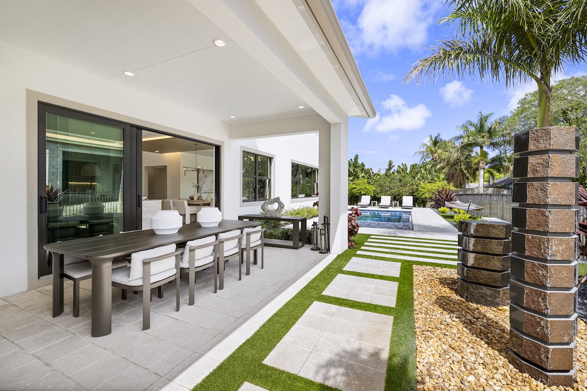 Outdoor living space with a dining table and pool.