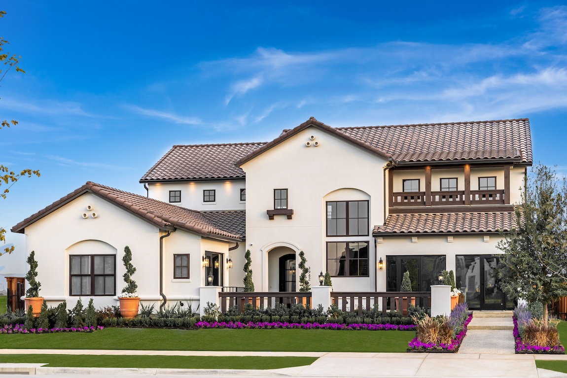 Tuscan-style home with symmetrical facade, tile roof, stucco exterior, and manicured front landscaping.