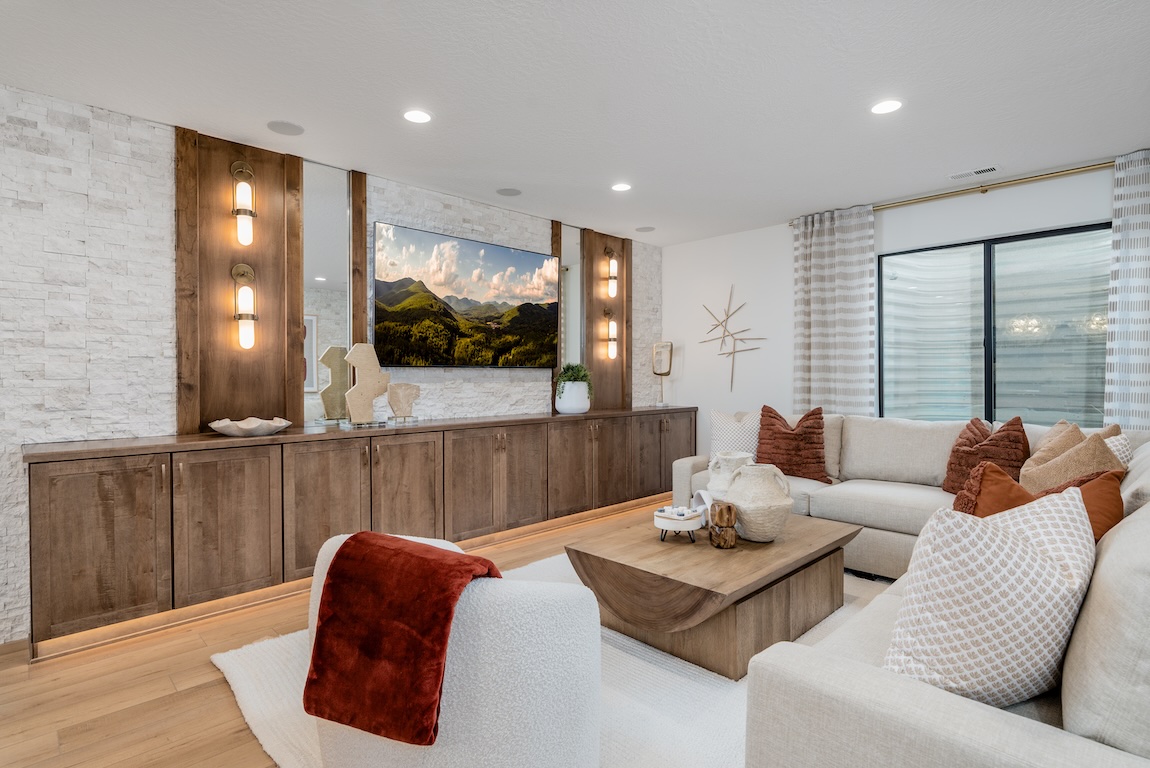 Modern entertainment room with warm wood accents, built-in cabinetry, and cozy neutral seating.