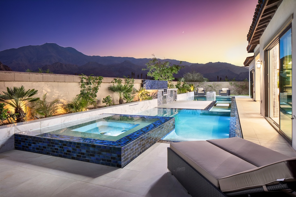 outdoor living space with pool and sunset views
