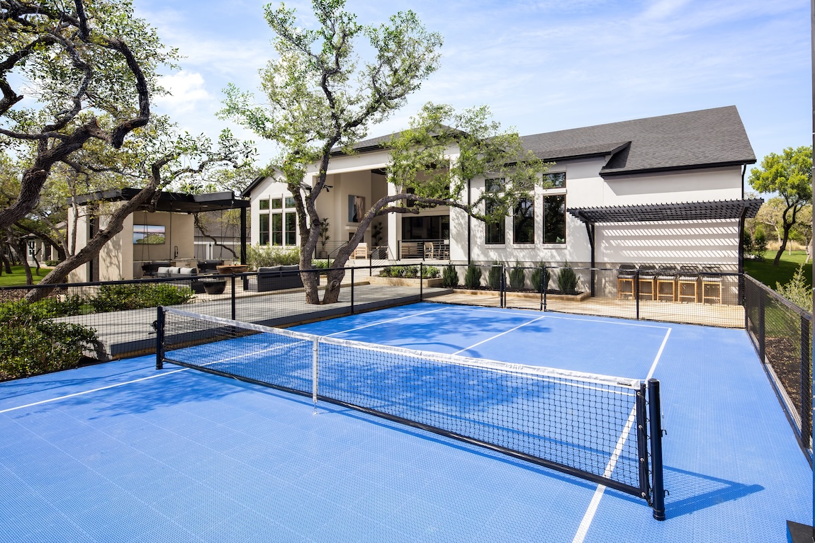 exterior of home with pickleball court and outdoor seating
