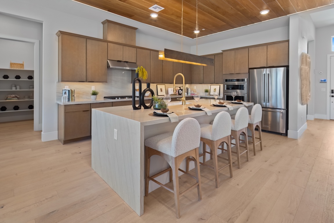 modern kitchen with wood cabinetry and a waterfall island.