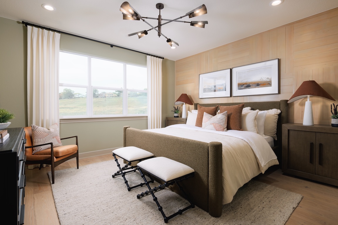primary bedroom with a wooden accent wall and neutral colors.