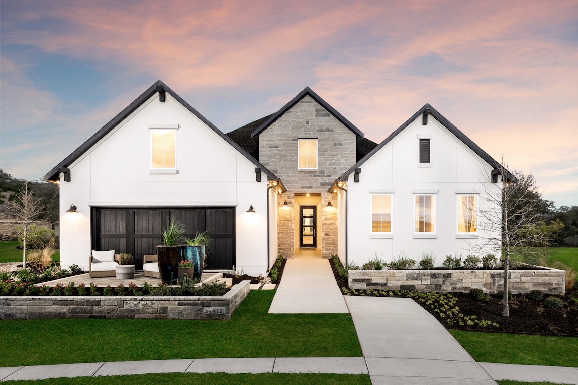 exterior of modern home with stone accents and warm interior lighting