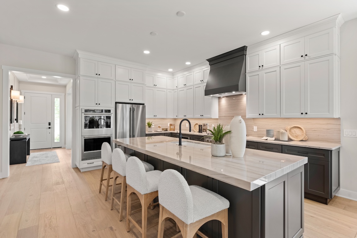 modern kitchen with island and seating and white cabinets.