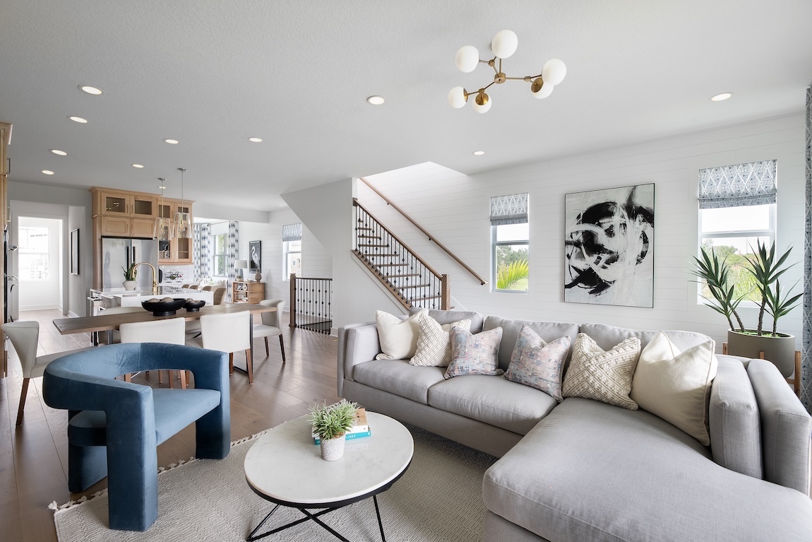 modern great room with color accents and open floor plan to the kitchen