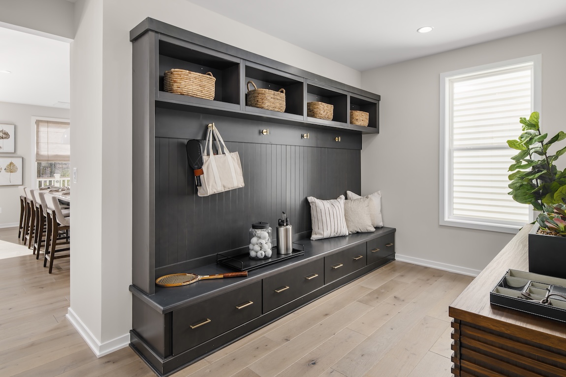 mudroom with storage bins and hooks for bags or jackets.