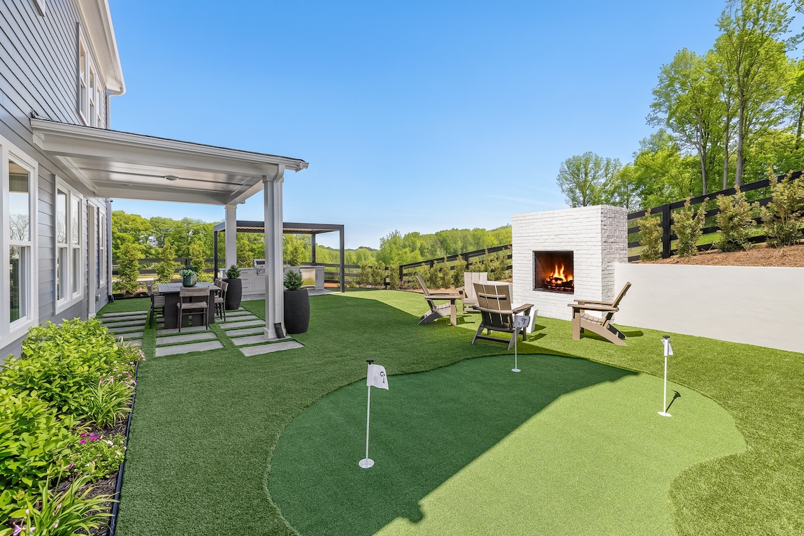 outdoor living space with putting green and fireplace