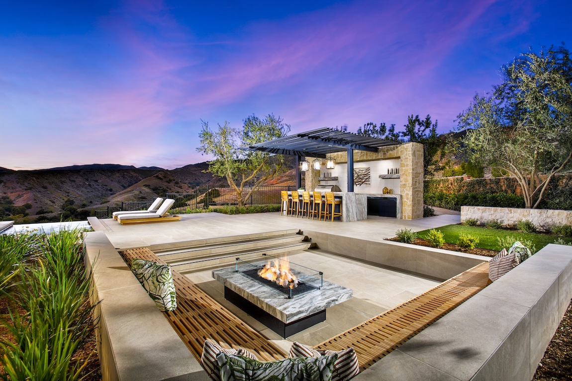 outdoor living space with firepit and bar area overlooking the mountains