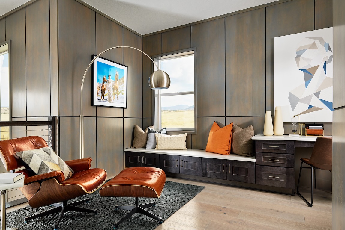 Modern loft with terracotta leather lounge chair, dark wood paneling, and built-in desk