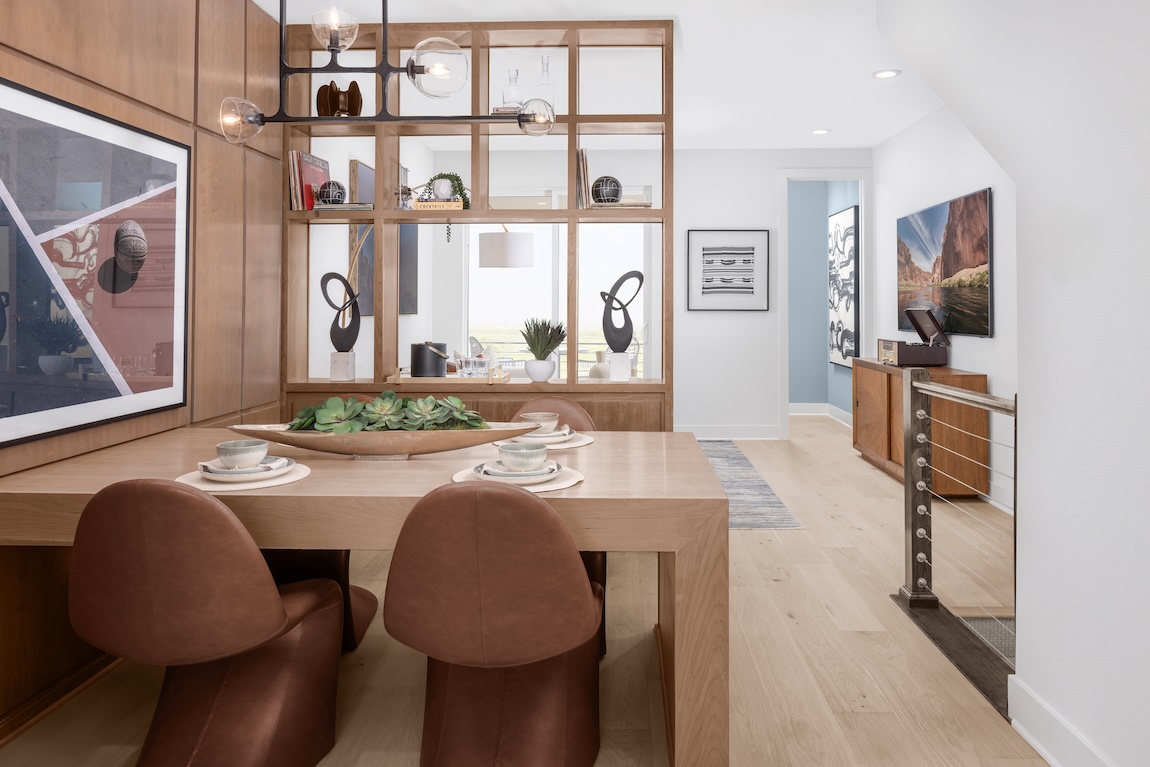 Dining room with terracotta leather chairs, neutral wallpaper, and botanical accents