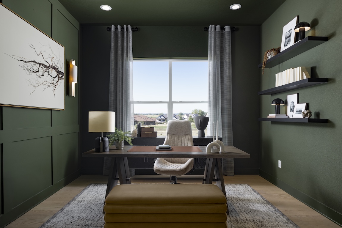 modern home office with green walls and a wooden desk