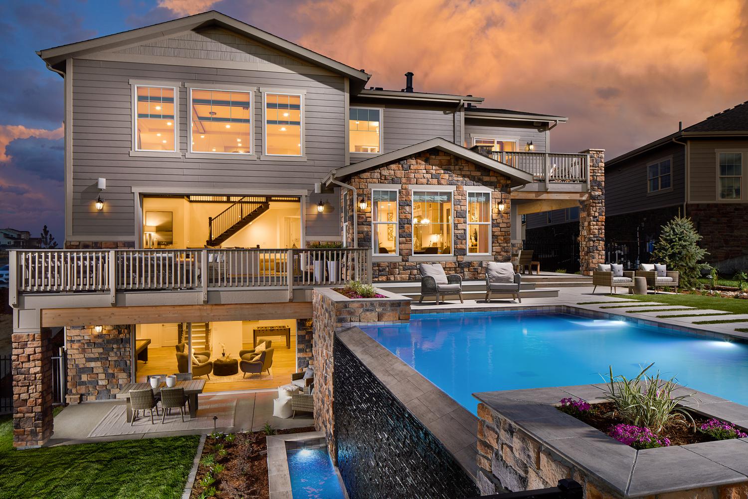 Back of a house with a pool and a backyard.