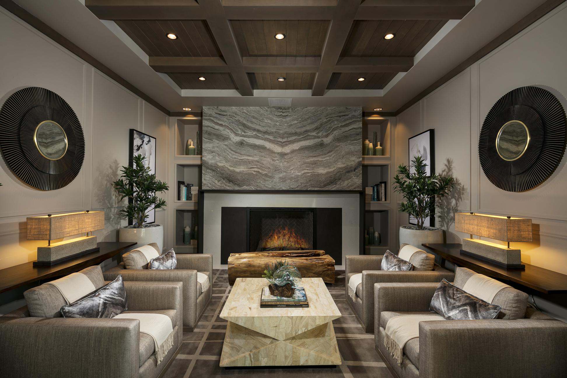 Living room with four large chairs in front of a fireplace.